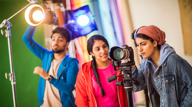 3 jovens dando ajustes finais em um set de filmagens antes de uma gravação